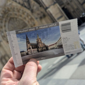 Mano del guía oficial Mateo sujetando las entradas para el circuito del Castillo de Praga en español frente a la Catedral de San Vito.