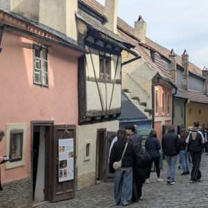 Turistas paseando tranquilamente frente a las famosas casas de colores del Callejón del Oro en el Castillo de Praga.