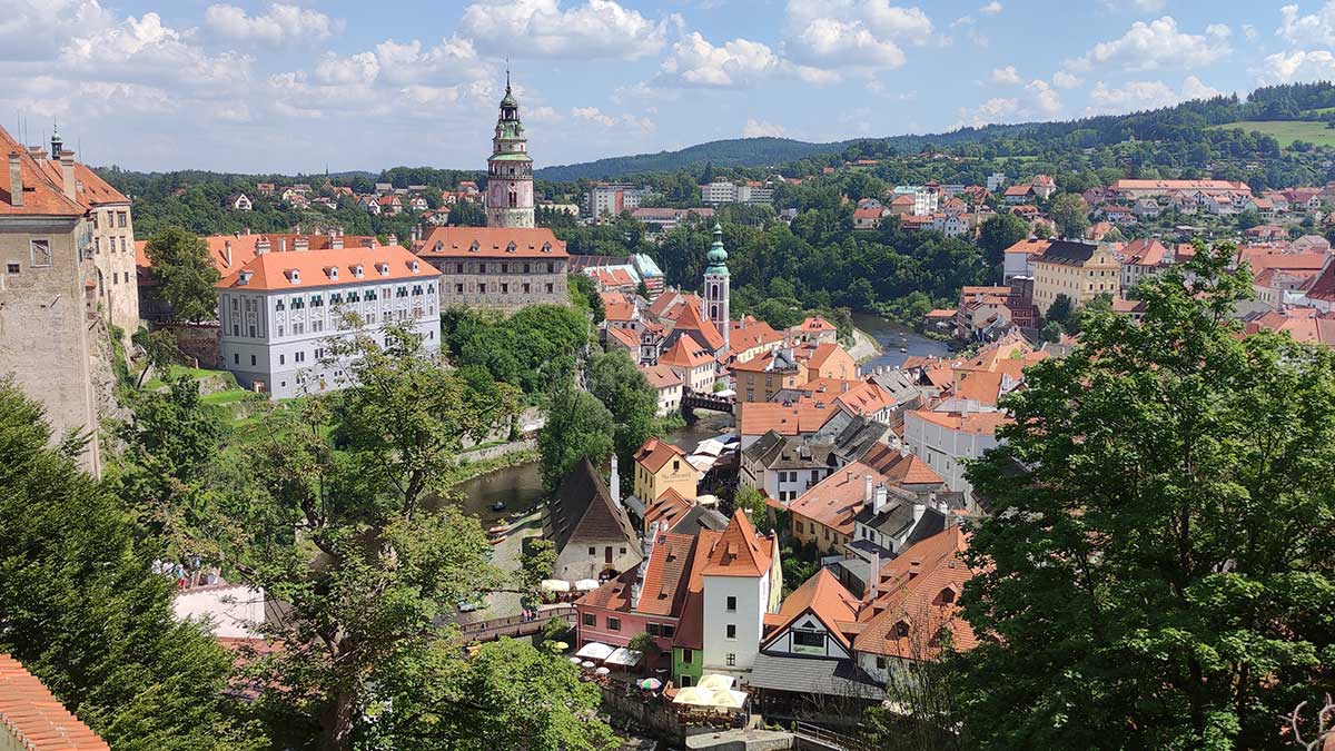 Panorámica de Český Krumlov: Centro Histórico y Castillo 2026 Vista panorámica de Český Krumlov con el río Moldava, los tejados rojos del casco antiguo y la torre del castillo desde un mirador