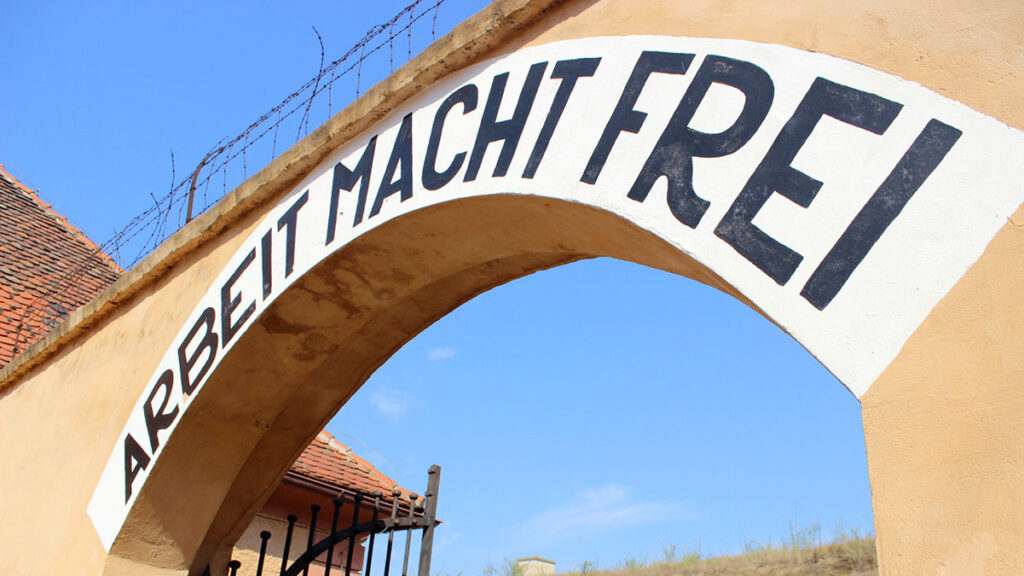 Arco de entrada al patio de celdas número 1 de la Fortaleza Pequeña de Terezín con el letrero de hierro 'Arbeit macht frei'.